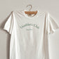 White shirt that says Unathletic Club Established 1991 in green 